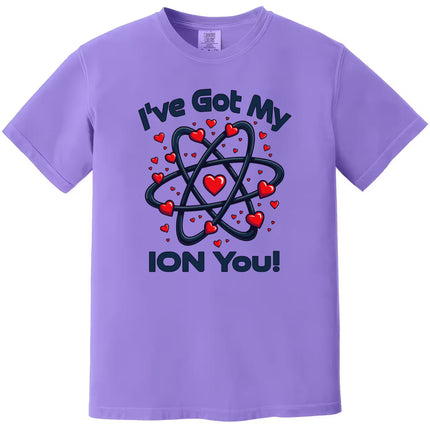 Purple “I’ve Got My Ion You” shirt flat laid, showcasing a cute nerdy chemistry Valentine design.