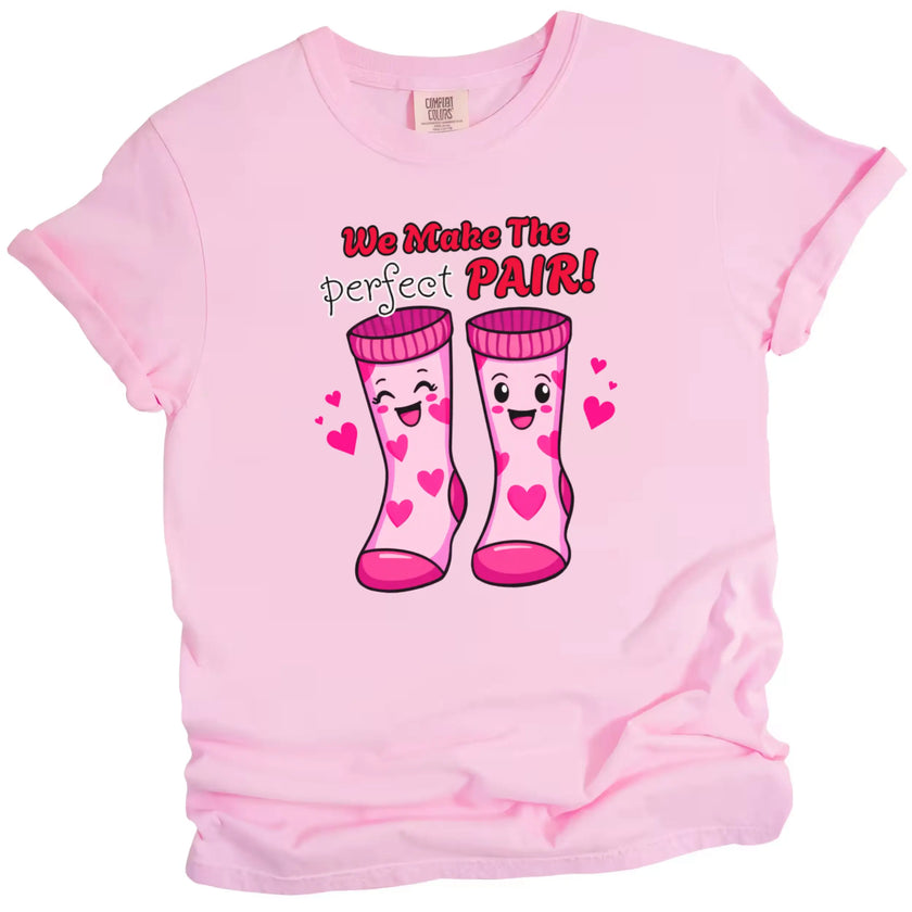 We Make the Perfect Pair t-shirt, pink shirt flat lay, playful Valentine socks graphic, fun unisex Valentine’s Day tee for gifting or couples