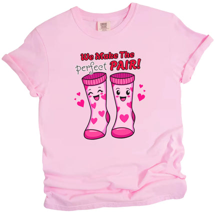 We Make the Perfect Pair t-shirt, pink shirt flat lay, playful Valentine socks graphic, fun unisex Valentine’s Day tee for gifting or couples