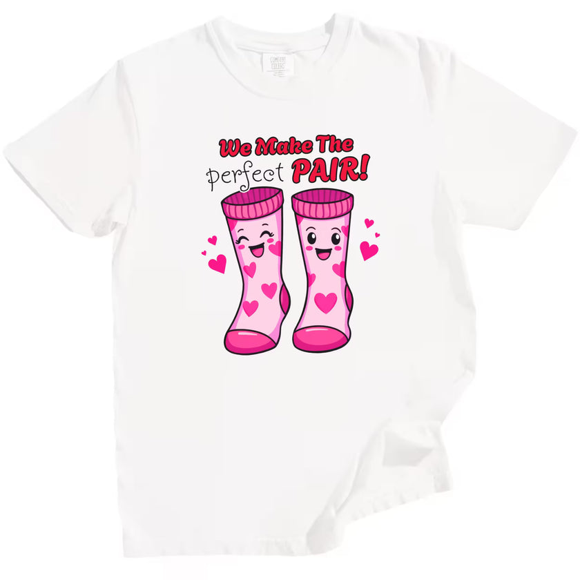 We Make the Perfect Pair t-shirt, white shirt flat lay, fun Valentine’s socks design, playful unisex graphic tee for romantic gifting or date nights
