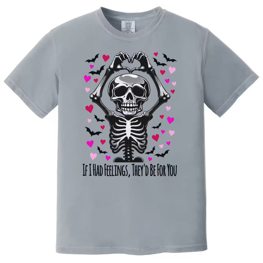 Gray shirt flat lay with spooky Valentine skeleton pun tee, heart hands gesture, and moody gothic design.
