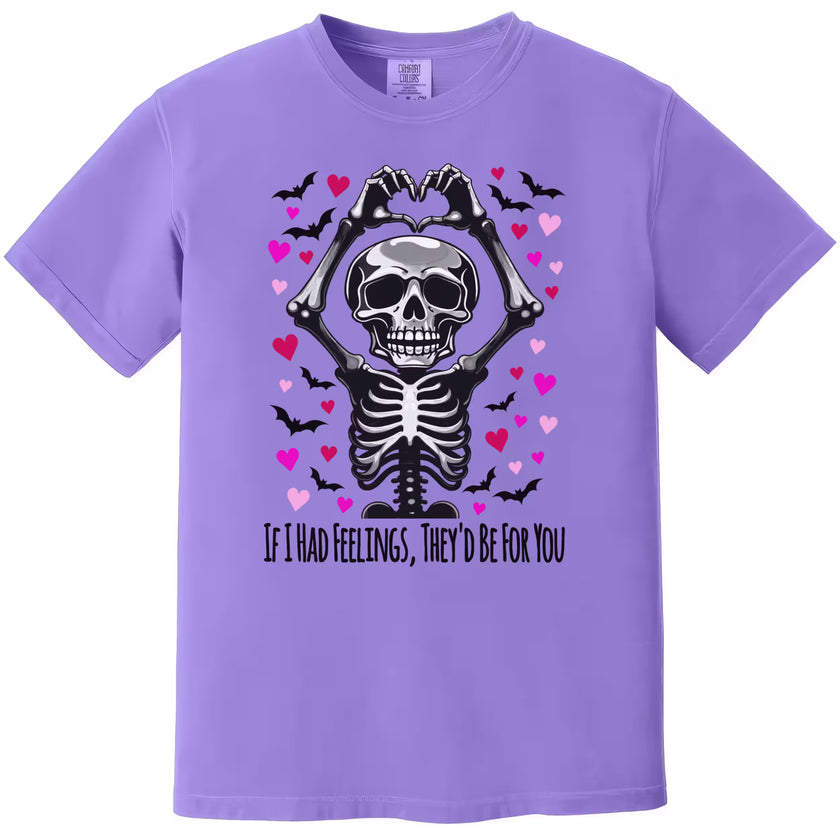 Purple shirt flat lay featuring skeleton making heart hands with pun “If I Had Feelings, They’d Be For You.”