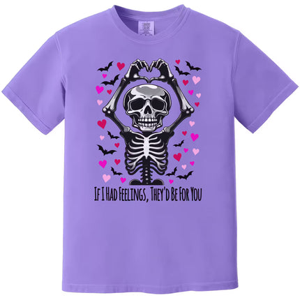 Purple shirt flat lay featuring skeleton making heart hands with pun “If I Had Feelings, They’d Be For You.”