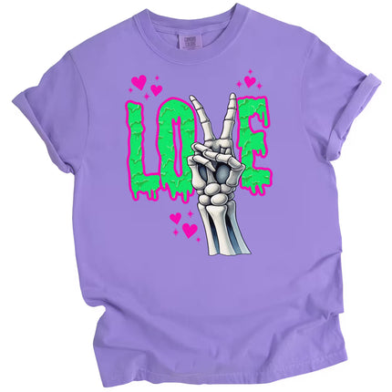 Gothic LOVE t-shirt flat lay in purple featuring skeleton peace sign and bright dripping green Valentine’s design.