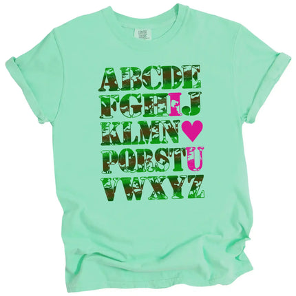 Bright green “I ♥ U” alphabet Valentine’s t-shirt flat lay, playful camo letters