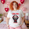 Female model wearing white “Love You to Death” horror clown Valentine shirt in bedroom with dark romantic vibe