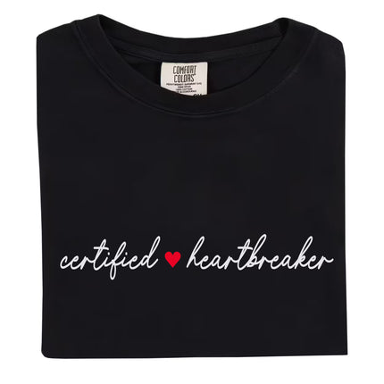 Minimalist Certified Heartbreaker tee in black with red heart and white script writing, flat lay on white background.