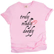 Pink Truly Madly Deeply graphic tee flat lay with black lettering and red heart accent, cute romantic shirt for women.