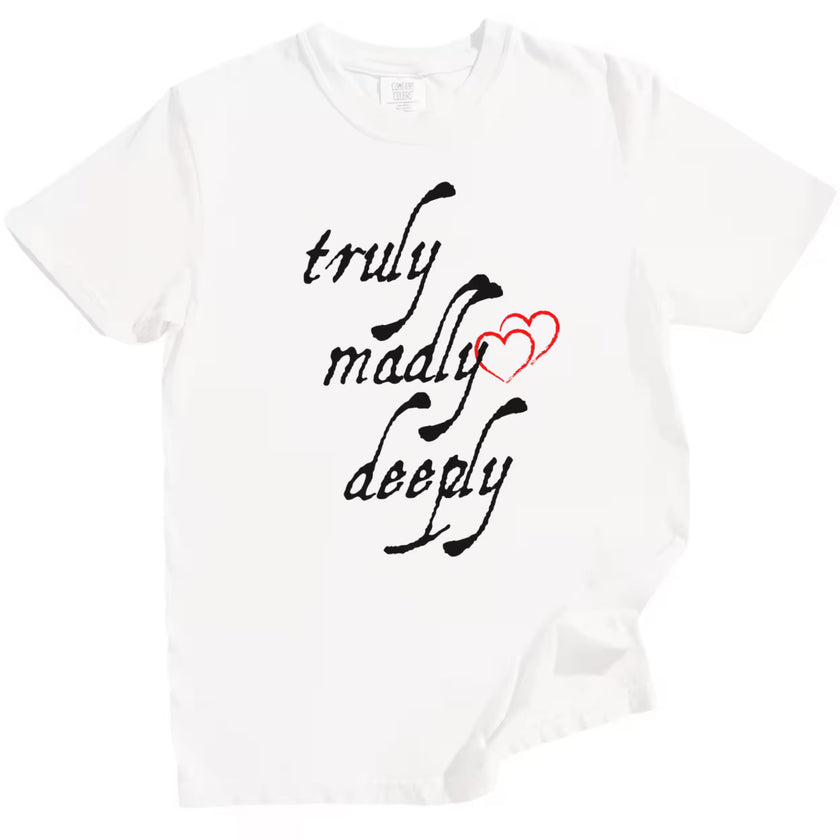 White Truly Madly Deeply t-shirt flat lay showing bold black lettering and red heart, romantic graphic tee for gifting.