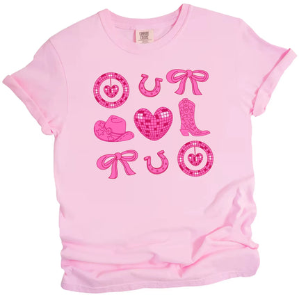 Pink cowgirl coquette Valentine’s tee with boots, hearts, and hats on a white background