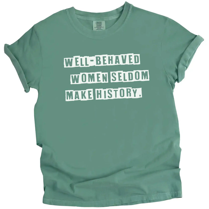 Green “Well-Behaved Women Seldom Make History” t-shirt flat lay featuring strong feminist quote and girls-supporting-girls energy