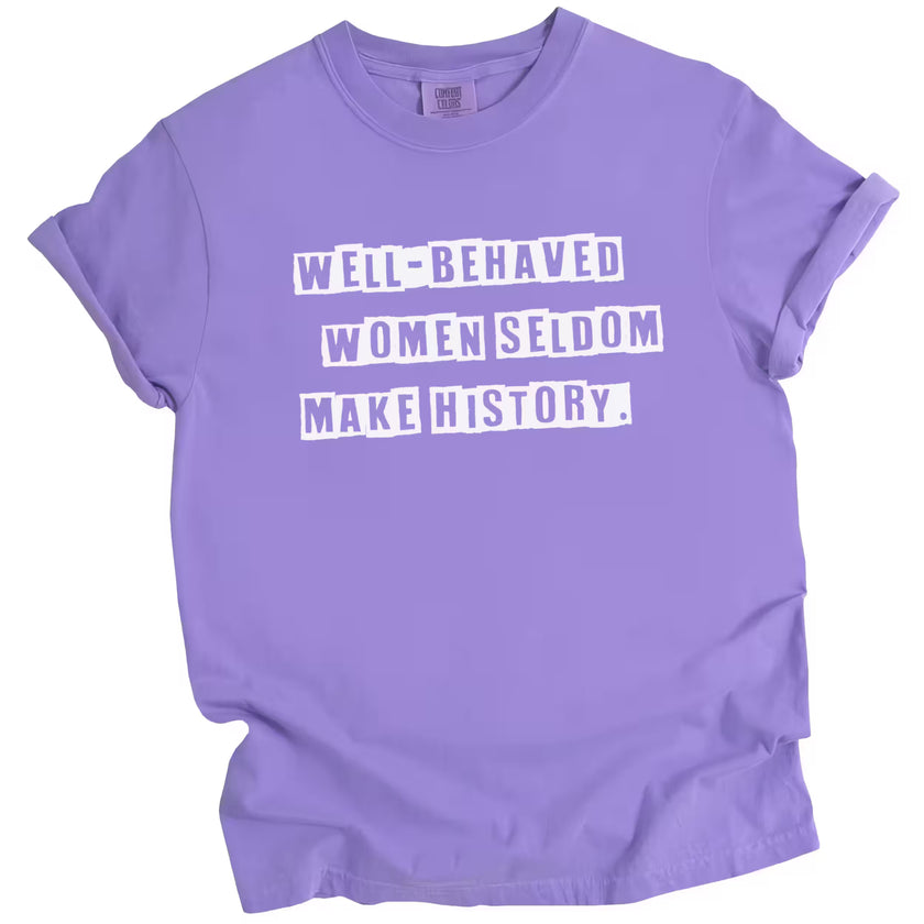 Purple “Well-Behaved Women Seldom Make History” t-shirt flat lay highlighting bold statement and feminist energy for women