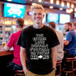 Man wearing a black Buffalo football t-shirt featuring the humorous ‘You Either Love Buffalo Football Or You’re Wrong’ design in pixelated lettering with a creative buffalo silhouette detail.